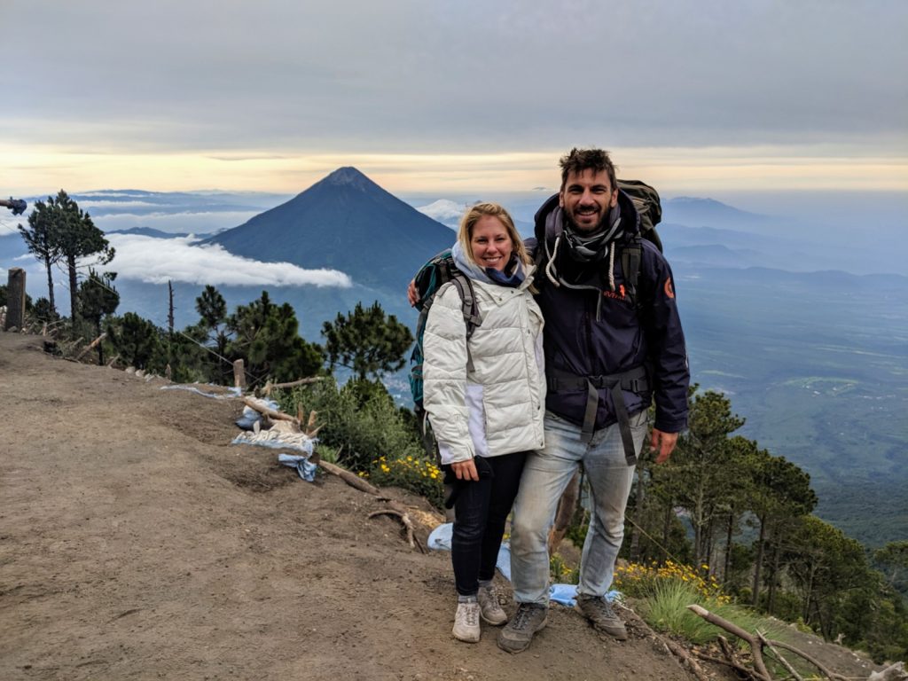 Hiker at Acatenango volcano base camp watching Fuego volcano eruption at night Guatemala — guided overnight tour from Antigua with Cyman Travel