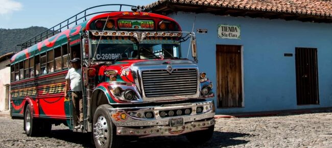 Shuttle van traveling from La Aurora International Airport in Guatemala City to the colonial streets of Antigua Guatemala with Agua Volcano in the background