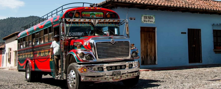 Shuttle van traveling from La Aurora International Airport in Guatemala City to the colonial streets of Antigua Guatemala with Agua Volcano in the background