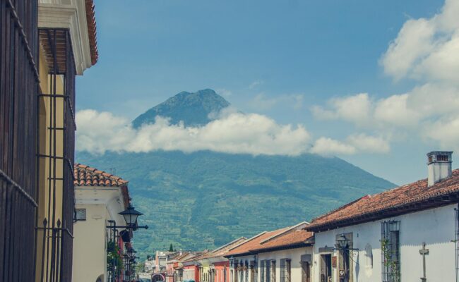 Vista aérea de la ciudad colonial de Antigua Guatemala, rodeada por los volcanes de Agua Fuego y Acatenango — recorrido por la ciudad con Cyman Travel