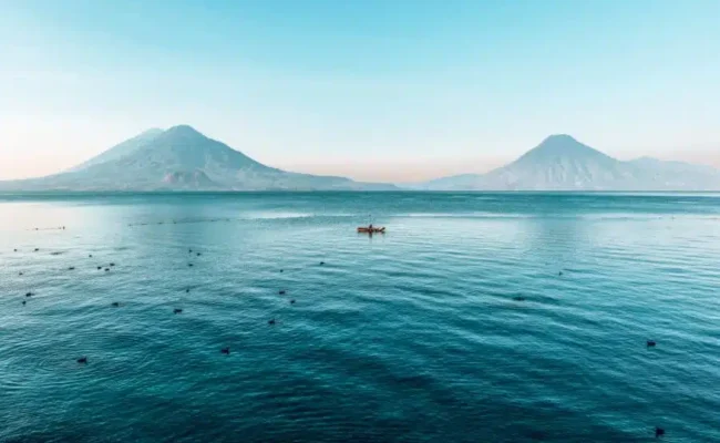 Vista panorámica del lago Atitlán, en Guatemala, con tres volcanes y pueblos mayas a orillas del lago — Visitas guiadas de Cyman Travel