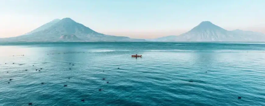 Vista panorámica del lago Atitlán, en Guatemala, con tres volcanes y pueblos mayas a orillas del lago — Visitas guiadas de Cyman Travel