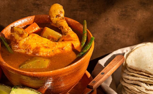 Traditional Guatemalan pepián stew served with rice and tortillas