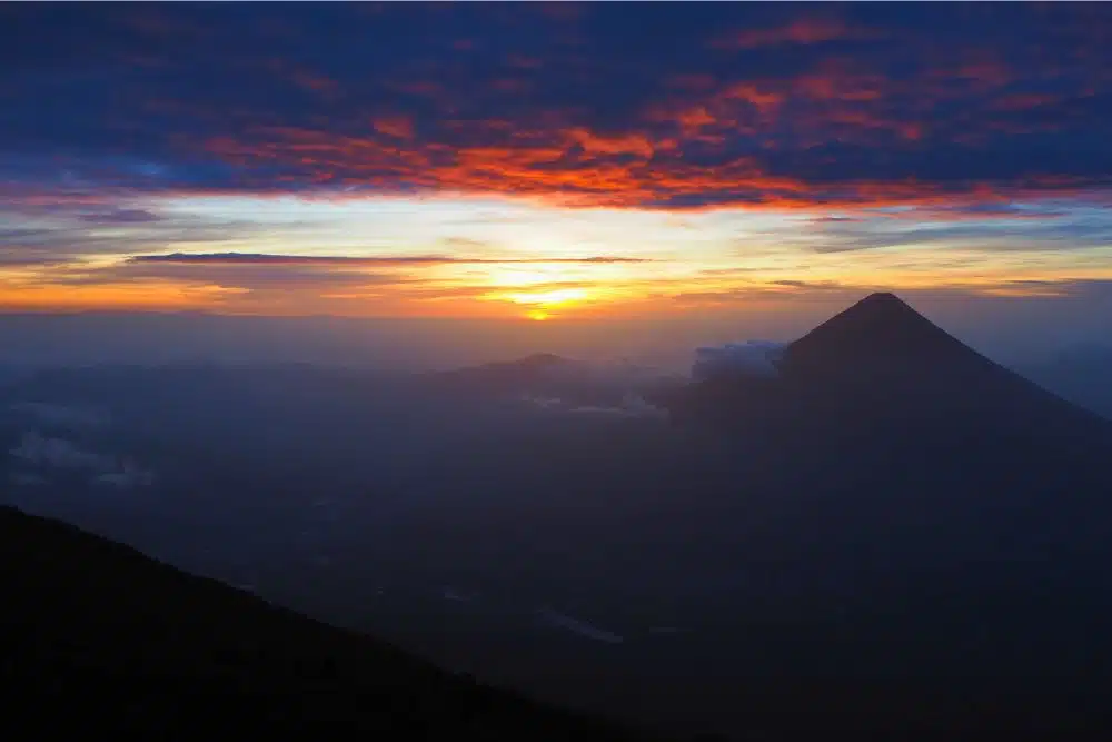 Sunrise above the clouds from Acatenango summit Guatemala with Pacific coast visible in the distance